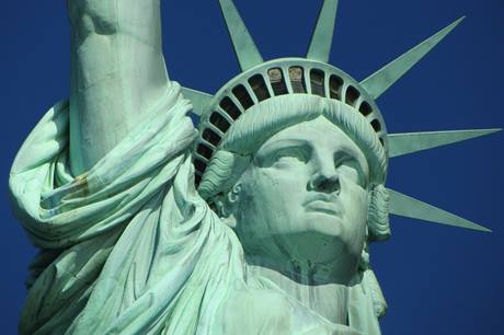 Imagem próxima do rosto da estátua da liberdade, em dia ensolarado sem nuvens