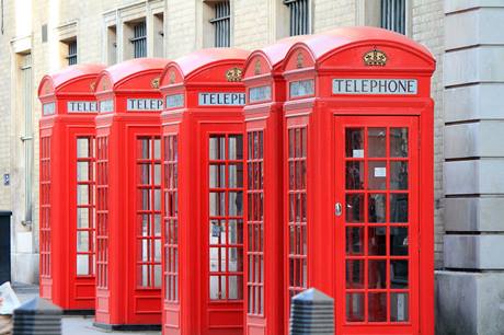 5 cabines telefônicas vermelhas enfileiradas 