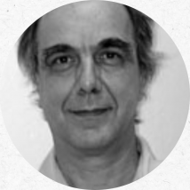 João Luiz Musa é um homem branco de cabelos curtos e grisalhos. Na foto, sorri sobre um fundo claro. Imagem em preto e branco.