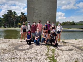 Foto colorida em ambiente externo, dos estudantes estrangeiros da ECA de 2022 na praça do relógio na USP