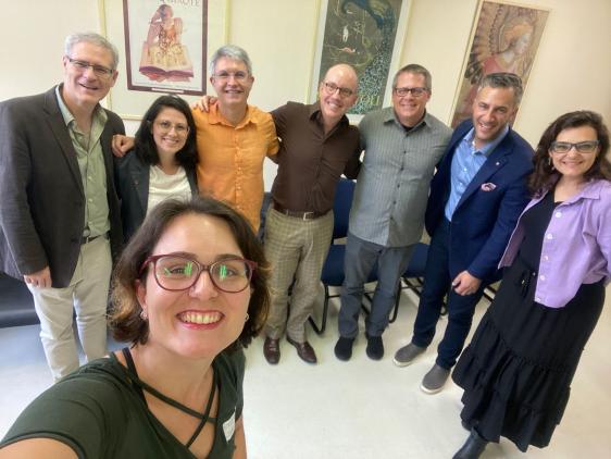 Foto colorida em ambiente interno, dos representantes da Ohio University e da ECA posando para a foto aos sorrisos