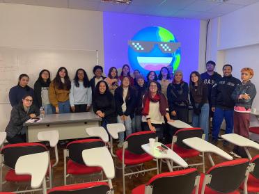 Foto colorida em ambiente interno, com os estudantes da ECA junto da funcionária Thaise Desirree