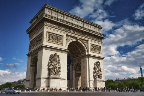 Foto colorida, em ambiente externo, do Arco do Triunfo na França, em dia ensolarado