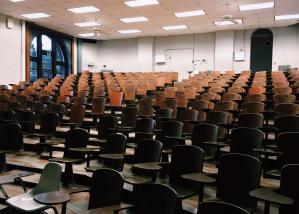 Sala de aula vazia com cadeiras de madeira