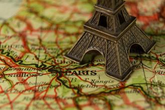 Imagem colorida de um mapa da França junto de uma miniatura da torre Eiffel