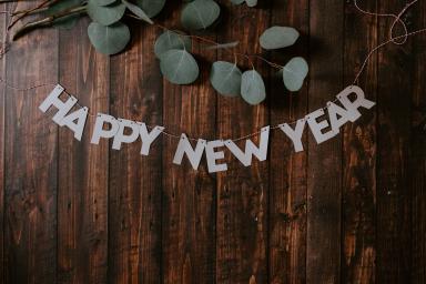 Imagem colorida, com "Happy New Year" escrito em letras garrafais.
