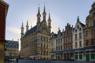 Foto colorida em ambiente externo, da prefeitura da cidade belga de Leuven, construída em arquitetura vitoriana