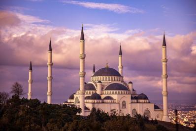 Foto colorida, em ambiente externo, de pôr-do-sol atrás de mesquita, em Istambul, Turquia