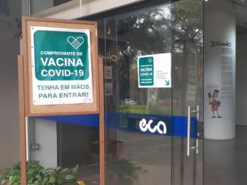 Foto colorida mostra mural na entrada do prédio principal da ECA com cartaz com os seguintes dizeres: "Comprovante de vacina covid-19. Tenha em mãos para entrar!"