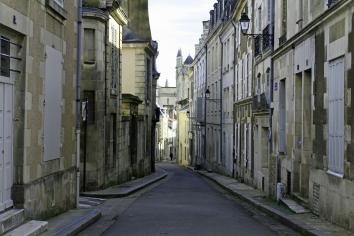 Foto colorida, em ambiente externo, de rua estreita, com construções de 3 andares bem antigas, em Poitiers, na França