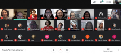 Imagem da reunião virtual. Cerca de 15 pessoas, em sua maioria mulheres, estão com as câmeras ligadas e sorrindo.  Cerca de 10 câmeras estão desligadas, mostrando apenas o ícone dos participantes.