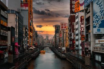 Foto colorida em ambiente externo, de um rio que cruza o centro urbano de Tóquio, no Japão.