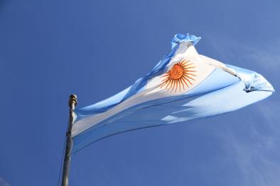 Foto colorida em ambiente externo, da bandeira da Argentina ao ar livre