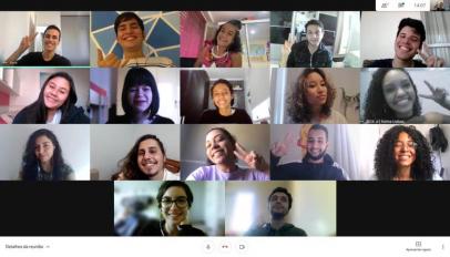 Print de tela de videoconferência da equipe da ECA Jr. A tela se divide em um mosaico com 17 retângulos, em que cada um deles mostra a imagem da câmera de cada um dos participantes. Eles posam para a câmera, sorrindo. 