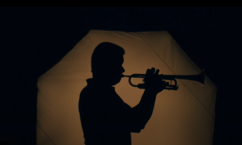 sombra de uma vista lateral de um homem trocando um trompete