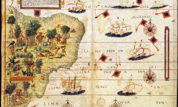 Mapa do Brasil do período colonial. À esquerda, está representada a parte costeira do Brasil, em cor verde-claro, com algumas gravuras de árvores, animais e indígenas. Na parte direita, em branco, está o mar, com desenhos de navios, bandeiras, rosas dos ventos e inscrições em Latim. 