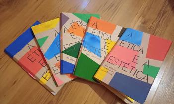 Foto de cinco livros cartoneros parcialmente sobrepostos formando um semicírculo. Todos possuem capas de papelão com formas geométricas coloridas e o título “A ética e a estética” em fonte preta. Estão sobre um piso de madeira.