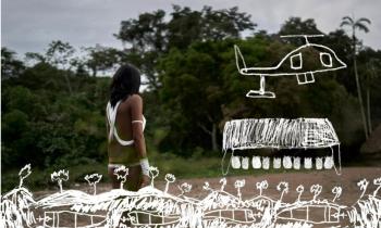 Foto de mulher indígena quase de costas em um campo aberto com floresta ao fundo e o céu nublado. Ela tem cabelos escuros e lisos de comprimento médio, usa tiras de tecido brancas cobrindo parte das costas, dos seios, punhos e o braço. Sobrepondo-se à parte de baixo dessa imagem, há desenhos em branco de estruturas em meio a árvores e, do lado direito,  um helicóptero acima de  uma construção maior. 