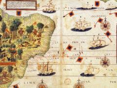 Mapa do Brasil do período colonial. À esquerda, está representada a parte costeira do Brasil, em cor verde-claro, com algumas gravuras de árvores, animais e indígenas. Na parte direita, em branco, está o mar, com desenhos de navios, bandeiras, rosas dos ventos e inscrições em Latim. 