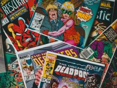 Foto das capas de várias revistas em quadrinho da Marvel, como Deadpool, espalhadas e sobrepostas. 