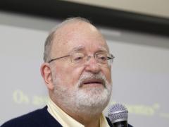 retrato do professor Frederic Michael Litto segurando microfone durante apresentação de palestra ou seminário