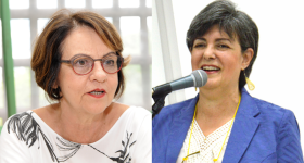 Foto das duas professoras. à esquerda, a professora Maria Cristina, uma mulher branca, aparentemente idosa, olhos castanhos, óculos redondos de armação vermelha e preta, cabelos claros um pouco abaixo das orelhas e a boca aberta como se estivesse falando. Ela usa uma blusa branca. à Direita, a professora Sandra Souza, uma mulher branca, de cabelos curtos e ligeiramente grisalhos. Ela veste uma blusa branca e um blazer azul. Na foto, ela fala ao microfone e sorri.