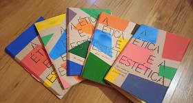 Foto de cinco livros cartoneros parcialmente sobrepostos formando um semicírculo. Todos possuem capas de papelão com formas geométricas coloridas e o título “A ética e a estética” em fonte preta. Estão sobre um piso de madeira. 